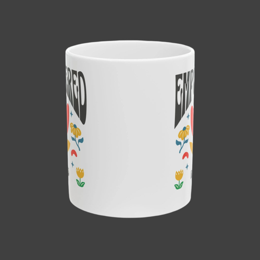 White mug with colorful floral designs and text on a white background