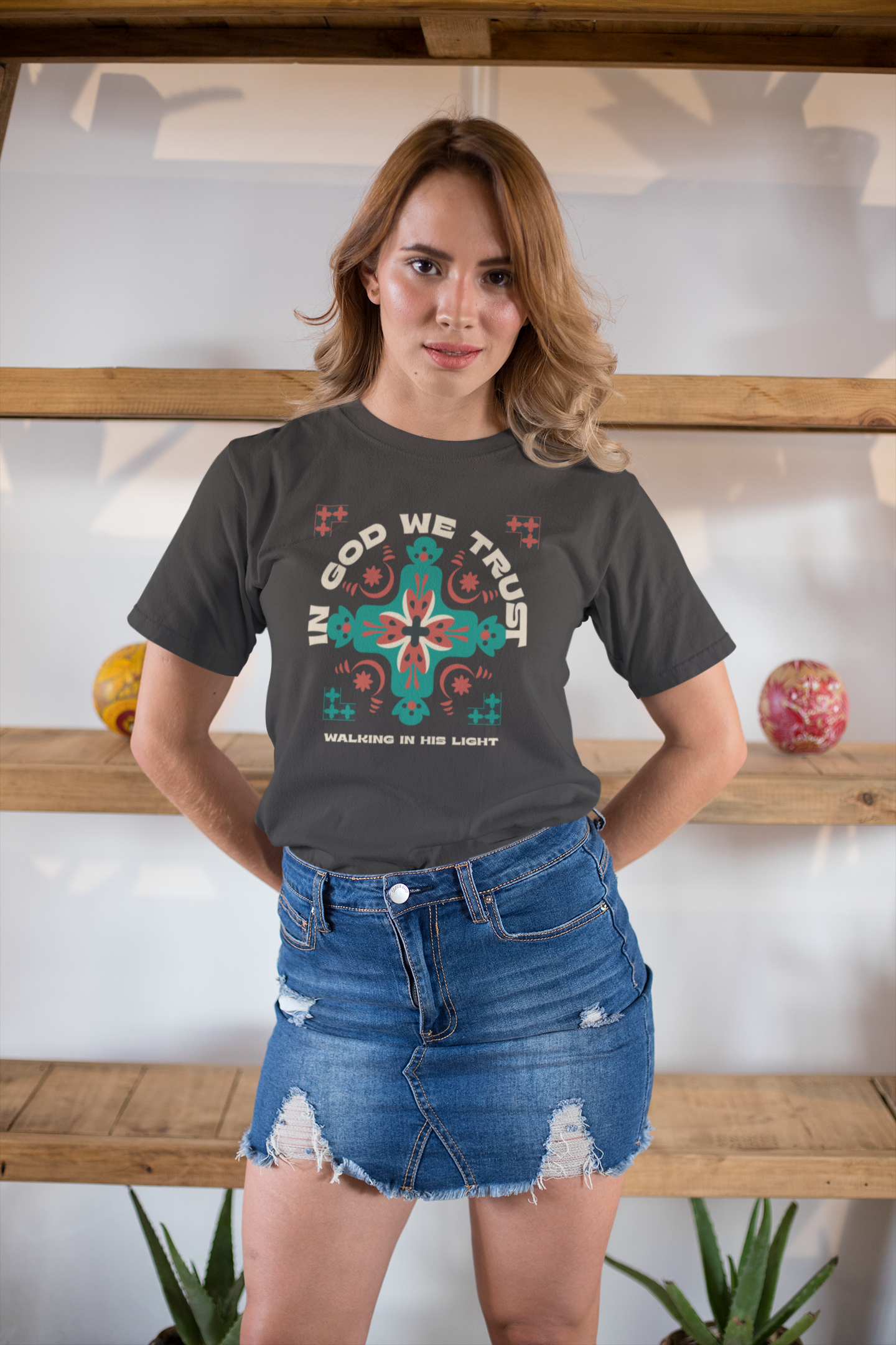 Woman wearing a dark gray t-shirt with a colorful graphic design, standing indoors.