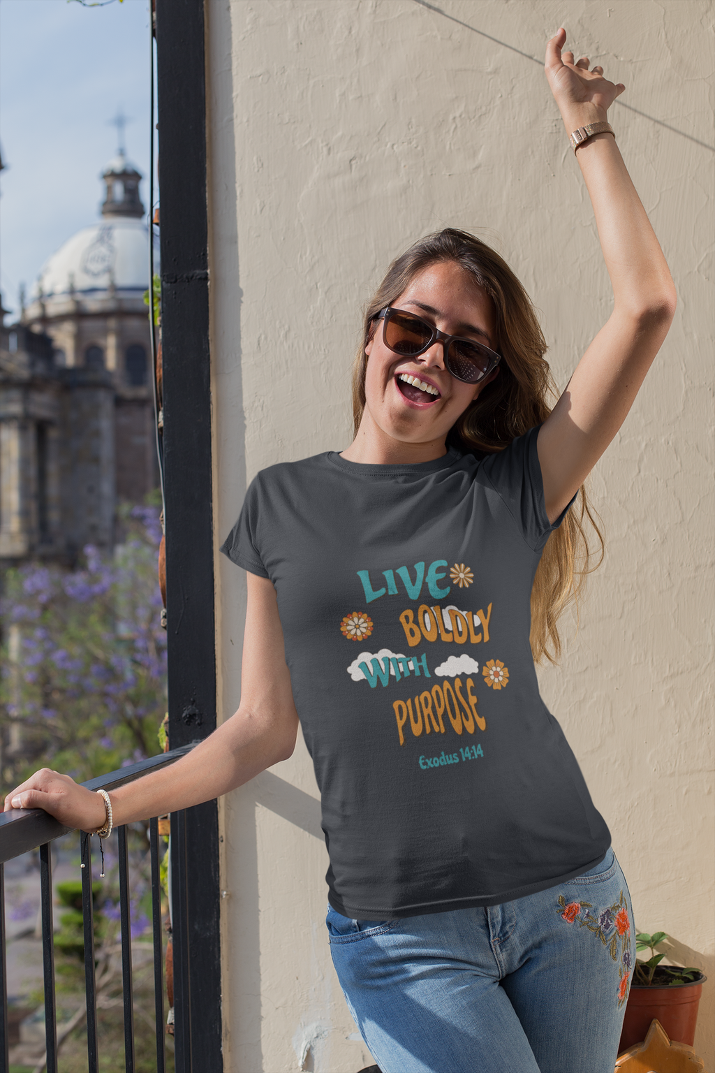 Woman wearing a t-shirt with motivational text, standing outdoors.